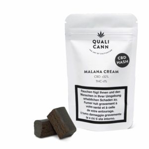 MALANA CREAM Hash mit bis zu 32% CBD | Qualicann. Weiße Verpackung mit schwarzem Qualicann Logo und Aufschrift. Links davon liegen zwei dunkelbraune CBD Hash Würfel.