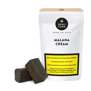Qualicann Malana Cream Premium CBD-Hash mit zwei dunklen Hash-Blöcken vor der passenden Verpackung auf hellem Hintergrund