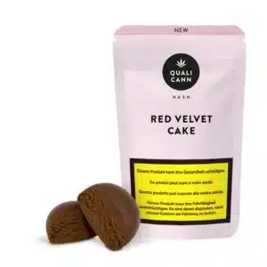 Qualicann Red Velvet Cake CBD-Hash mit zwei braunen Hash-Blöcken vor der passenden rosa Verpackung auf hellem Hintergrund